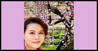 Aoi Saito smiles behind cherry blossoms