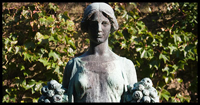 Female Statue holds fruits in either hand